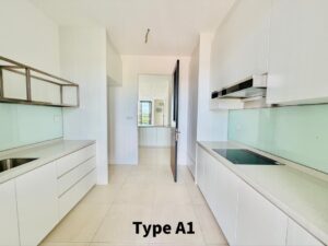 Bright white galley kitchen with handleless cabinets, glass backsplash, left sink, right induction stove, view toward doorway.