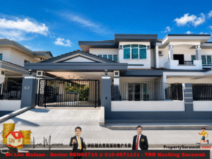 Modern two-story house with dark blue accents and a gated driveway under a blue sky; real estate banner across bottom.