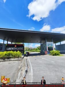 Entrance to Liberty Grove building with a dark canopy under a bright blue sky and white clouds; prominent 'LIBERTY GROVE' sign on the facade.