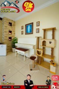 Showroom interior with a white piano, cat tree, framed photos, and a “FOR SALE” ad overlay for a property listing in Kuching.
