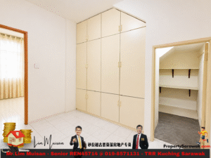 Room with tall beige built-in wardrobes along the wall, a doorway on the left with sheer curtains, and a small closet with shelves on the right.