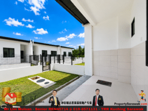 Modern white residential complex courtyard with tiled patio, green lawn and blue sky, viewed from a covered walkway.