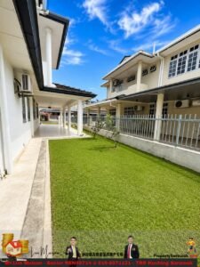 Courtyard between white two-story buildings with a green lawn, walkway, and bright blue sky above.