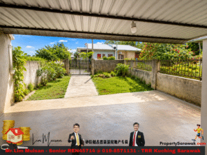 Covered patio overlooking a small garden and gate; concrete path leads to a fenced yard with greenery and a neighboring house visible in the distance.