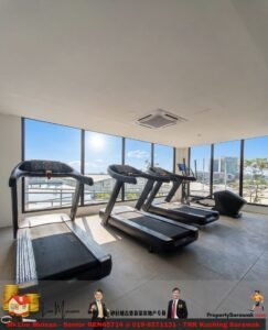 Three treadmills lined up in a bright gym, facing large windows with a city skyline outside and sunlight streaming in.