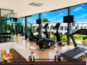 Bright gym with cardio machines (treadmills and ellipticals) along large glass windows facing a sunny outdoor area, weights area visible to the left.