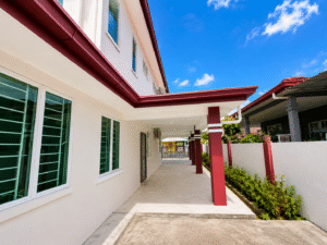 Wide walkway along a cream-colored building with red support columns and a bright blue sky.