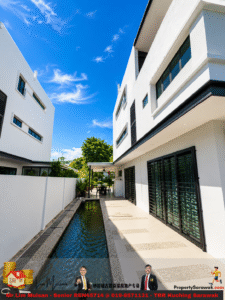 Modern white townhouse complex with a long narrow water feature running along a tiled patio under a bright blue sky.