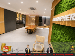 Modern office lounge with a long wooden table, surrounding chairs, dividers, and a moss wall with a white sign on the right.