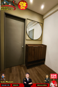 Modern hallway with a gray door on the left, a large circular mirror above a dark wood console cabinet, and warm ceiling lights.