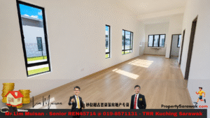 Bright empty open-plan room with light wood flooring, white walls, several tall windows, and a small kitchenette area at the far end.
