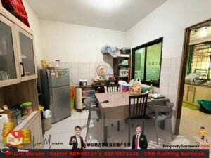 Cluttered dining area in a compact kitchen: table with bags and containers, fridge, and shelves nearby.