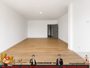 Empty white-walled living room with light wood flooring and an open gray door to a hallway. (Image includes a real estate banner at the bottom.)
