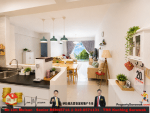 Bright open-plan living area featuring a kitchen island, dining table, and beige sofas with a balcony view through large windows. - Pendant lights above the island and green plants scattered around the space.