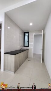 Modern galley kitchen with beige tiled walls, black countertop, and a double sink under a narrow window; door to a hallway on the right.