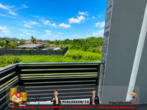 Balcony railing frames a view of a lush green field, palm trees, and distant houses under a bright blue sky with scattered clouds.