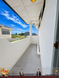 Narrow white balcony with tiled floor, railing and a column, overlooking a blue sky and distant buildings.
