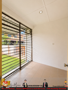 Unfurnished tiled room with a large metal horizontal-bar window grille, sunlight casting shadows on the beige floor and white walls outside view of a yard and houses