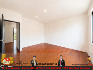 Empty white-walled room with warm wood floors and a large window on the right; open doorway to a sunlit adjacent room.