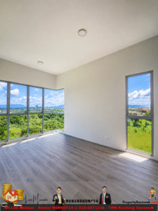 Bright empty room with gray wood floor and large windows showing green hills and blue sky outside.