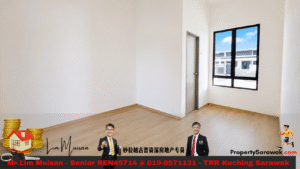 Empty sunlit room with light wooden floor, white walls, a large black-framed window, and a doorway nearby.