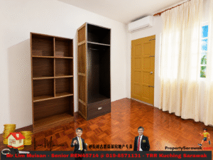 Room with warm wooden parquet flooring, two tall wooden shelves, a dark open wardrobe, a mustard-yellow door, and sheer white curtains by a window.