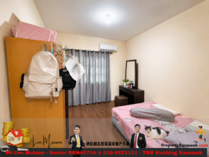 Small bedroom with a pink-themed bed, dresser, and hanging backpacks on a wardrobe door; gray curtains over a window on the far wall.