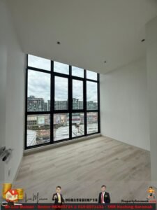 Empty modern room with large black-framed windows overlooking a city, light wood floor, white walls and ceiling; bright, open space ready for furnishing.