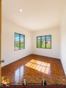 Empty unfurnished room with white walls, two windows with metal bars letting in sunlight, and a glossy wooden parquet floor.