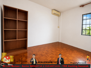 Empty room with a tall wooden bookshelf on the left, a window on the right, and a wall-mounted air conditioner above.