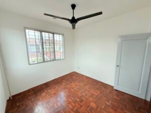 Empty room with parquet floor, white walls, a barred window, and a black ceiling fan nearby.