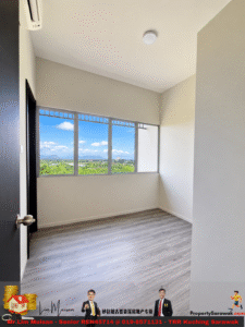 Empty modern room with a large window overlooking a green landscape and blue sky; light gray wood flooring and white walls, door ajar on the left.