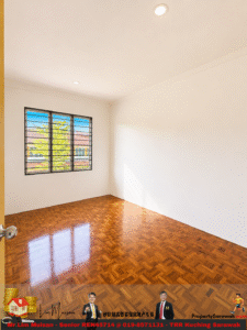 Empty sunlit room with white walls, polished parquet floor, and a large window with metal bars showing a sunny exterior street.