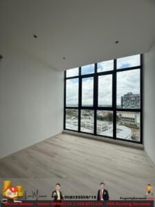 Empty room with light wood flooring and a large grid window showing a cityscape and blue sky outside.