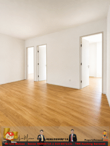 Empty white-walled room with warm wooden flooring and three open doorways leading to other bright rooms.
