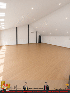 Spacious empty hall with light wood floor, white walls, and a curved ceiling; recessed lights, left skylights, black vertical supports, and a door at the far end.