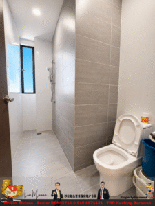 Narrow modern bathroom with gray tiled walls, a walk-in shower at the far end, and a white toilet on the right.