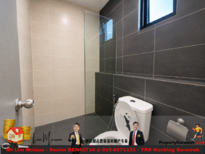 Modern bathroom with glass shower enclosure, beige left wall tiles, dark gray right wall tiles, and a white toilet near a high window.