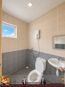 Small tiled bathroom featuring beige upper walls and gray lower tiles, with toilet, sink, wall-mounted shower unit, window, and mirror.