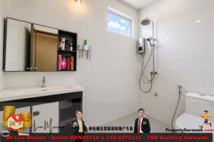 Bright modern bathroom with a white sink on a black vanity, a wall-mounted medicine cabinet with open shelves of toiletries, and a large window over a spacious shower area with a rainfall head; a white toilet is visible to the right. An advertising banner runs along the bottom of the image.