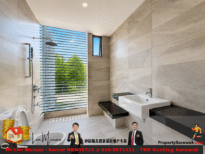 Modern bathroom with a large window and horizontal blinds, view of trees outside; left is a shower area, right has a white sink on a black countertop.