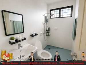 Bright minimalist bathroom with a wall mirror, sink, toilet, open-shower area, and a window with grid panes; teal towels and black shelves accent the space; a bottom advertising banner is visible in the image.