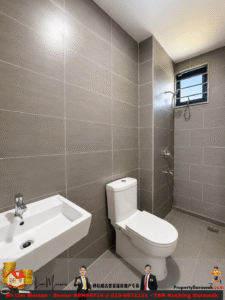 Modern gray-tiled bathroom with a white toilet, wall-mounted sink, and a shower area with a small window in the corner.