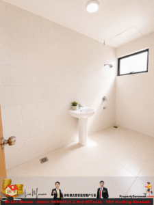 Bright white bathroom with large wall tiles, pedestal sink, small potted plant, and a wall-mounted shower fixture under a rectangular window.