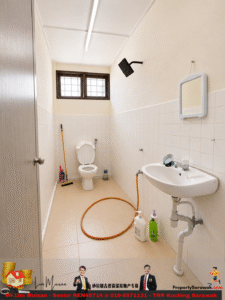 Narrow bathroom with toilet at far end, wall shower, and white sink on the right; orange hose looping on beige tiled floor, cleaning supplies nearby.