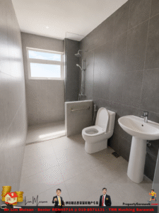 Modern gray-tiled bathroom with a glass-panel shower, toilet, and pedestal sink under a window.