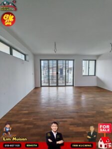 Empty living room with wooden floors, large glass doors to a balcony, and white walls; ceiling wires hanging down, suggesting ongoing renovation; branding overlays in the corners indicate a property listing.