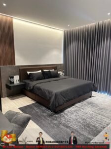 Modern bedroom with a large dark bed, black bedding, and a padded headboard, beside a floating nightstand with a book and decor.